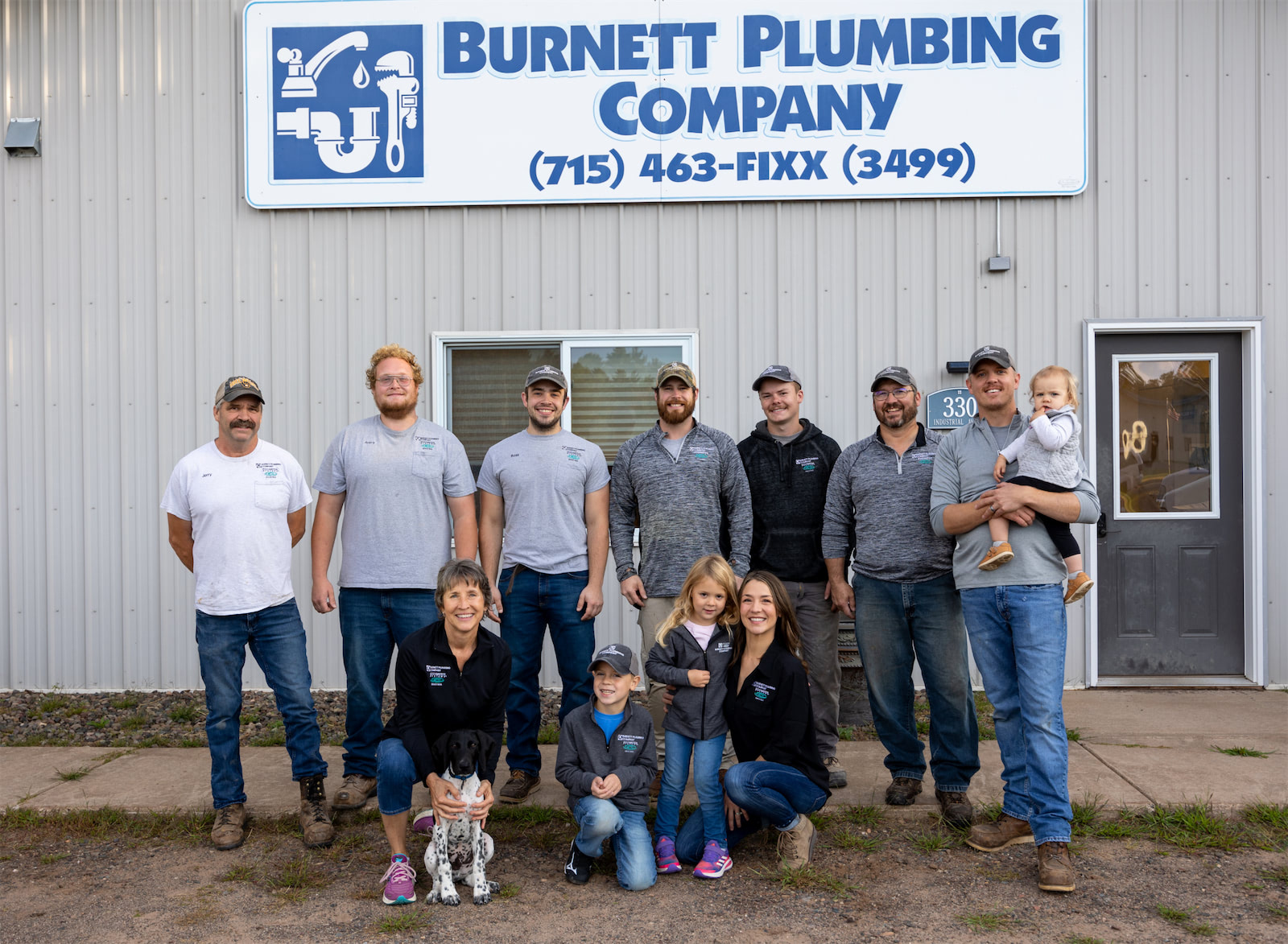 A close-up group photo of Burnett plumbing company employees.